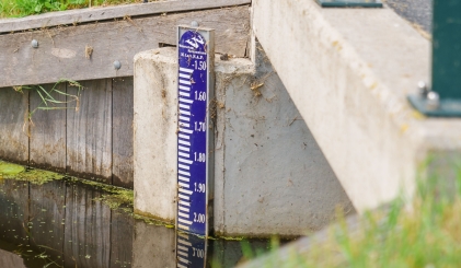 NAP waterpeilstok tegen een bruggetje aan