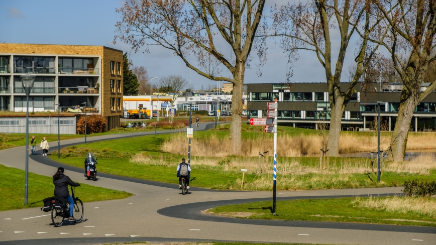 Fietsers op slingerende paden tussen bomen in stedelijk gebied van Leiden