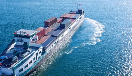 Een containerschip vaart over een helderblauw water