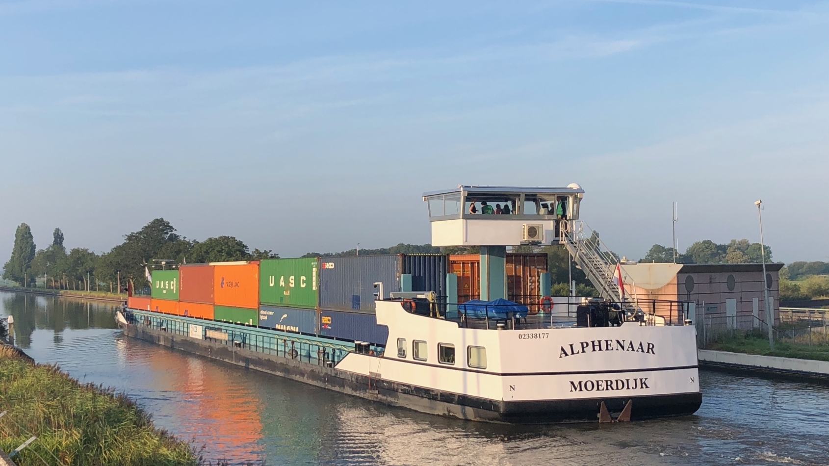 Het eerste binnenvaartschip op batterijen vaart door een Hollands landschap