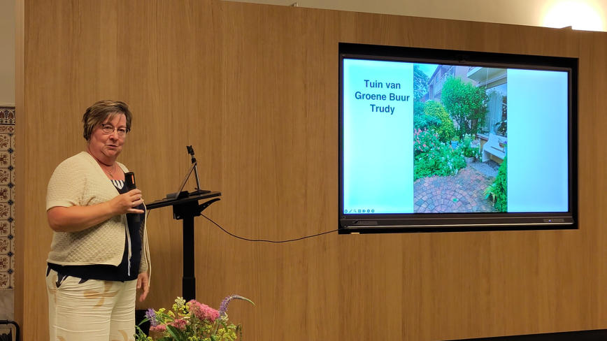Buurvrouw Trudy presenteert haar groene tuin aanwezig