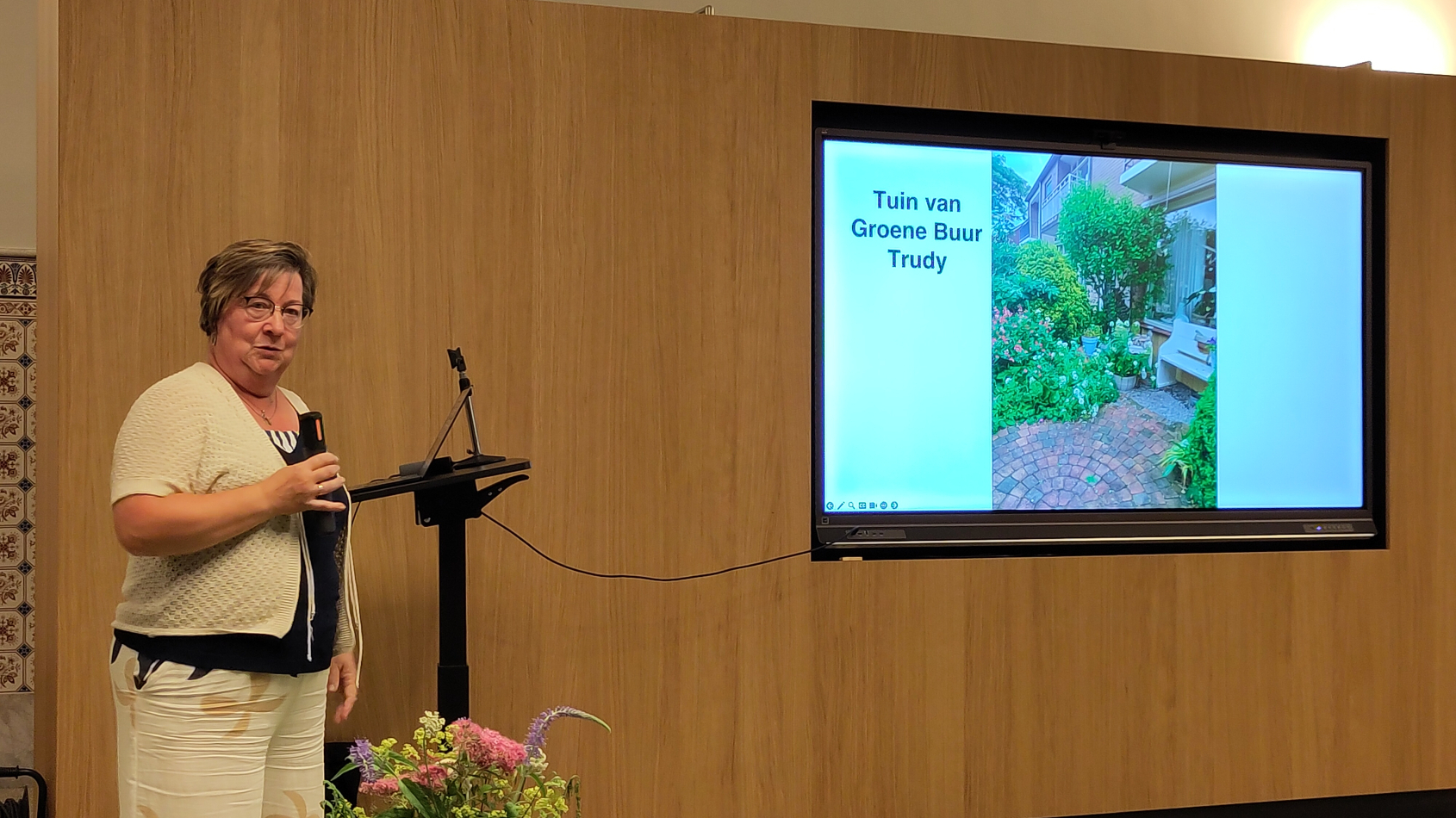 Buurvrouw Trudy presenteert haar groene tuin aanwezig