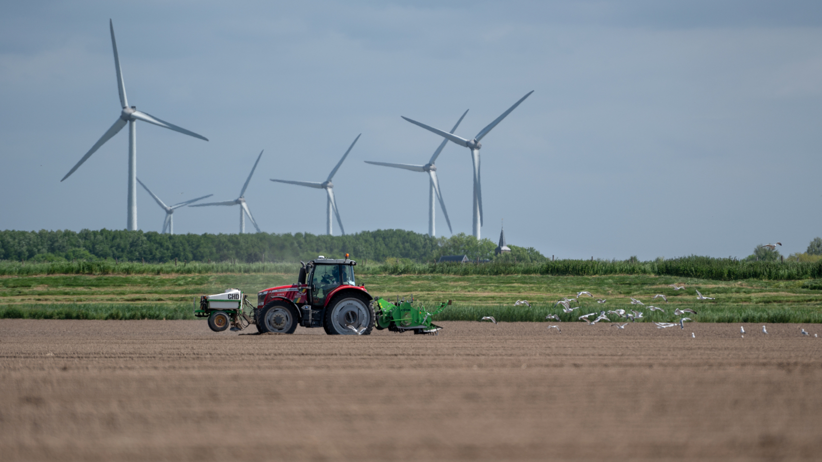 Tractor rijdt mest uit op een akker