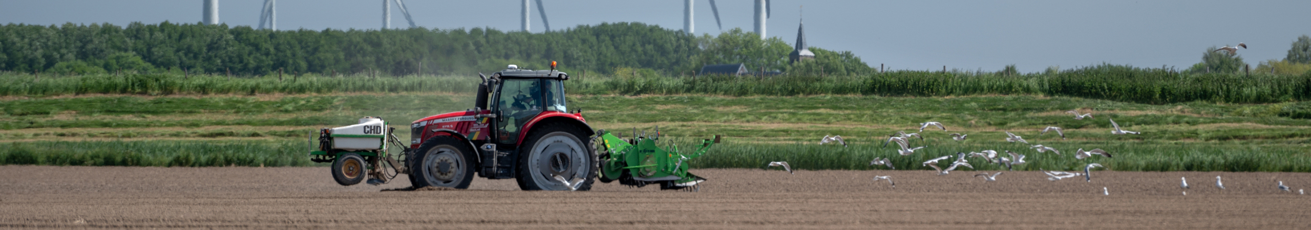 Tractor rijdt mest uit op een akker